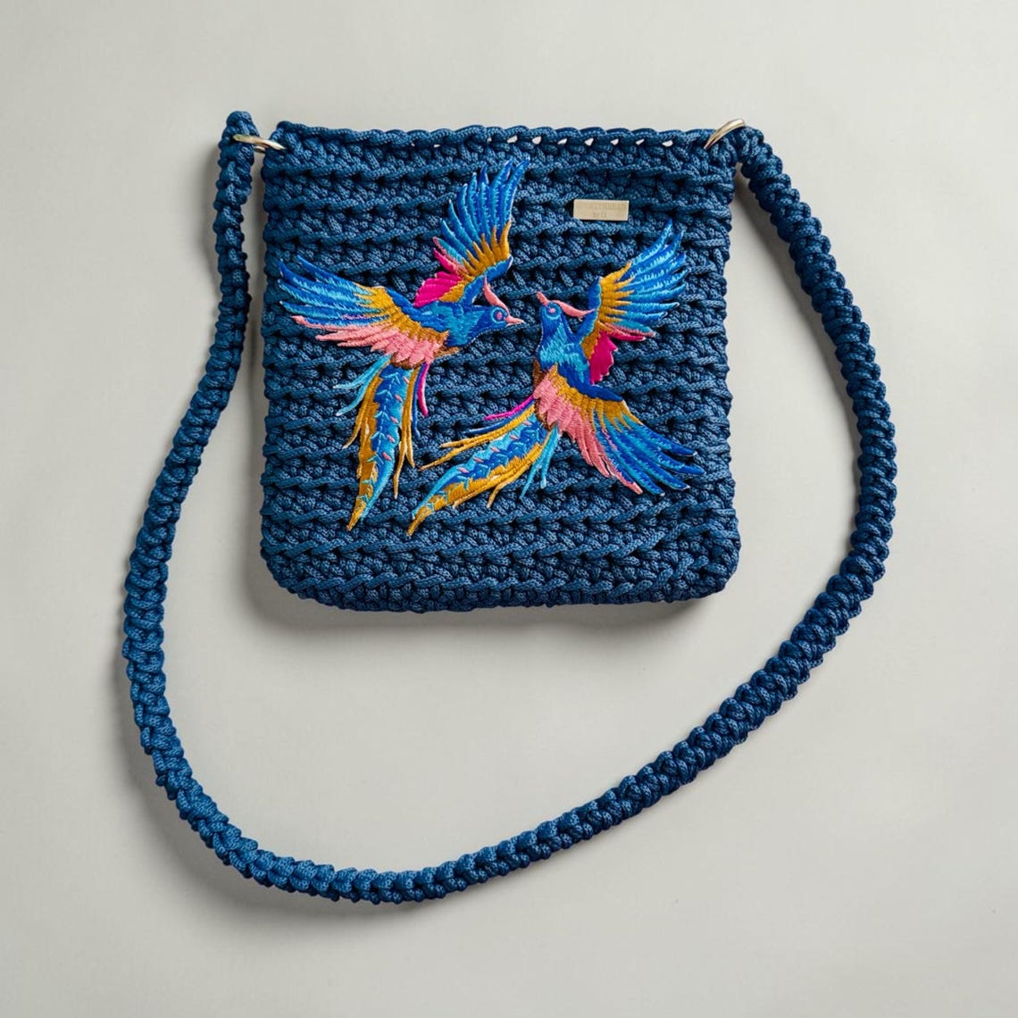 Blue crochet shoulder bag with colorful bird appliqué