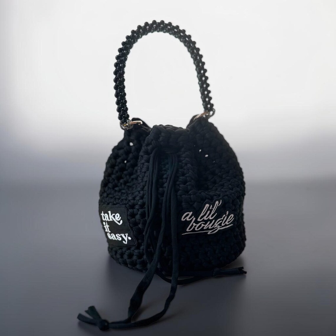 Handmade black t-shirt yarn bucket bag with statement patches