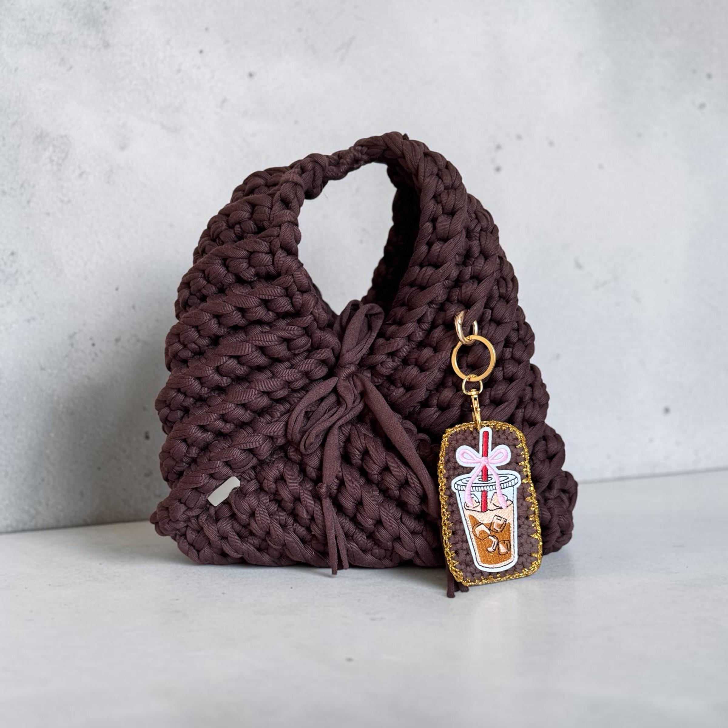 Handmade chocolate-brown triangular crochet handbag with an iced coffee charm