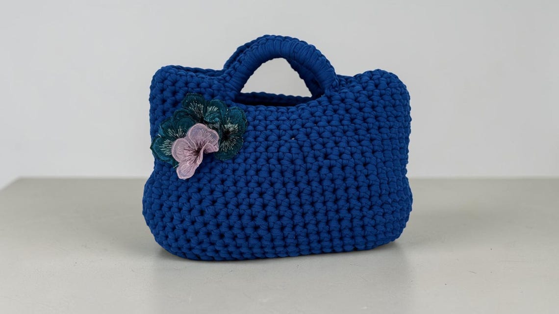 Cobalt blue crochet mini handbag with embroidered floral appliqué