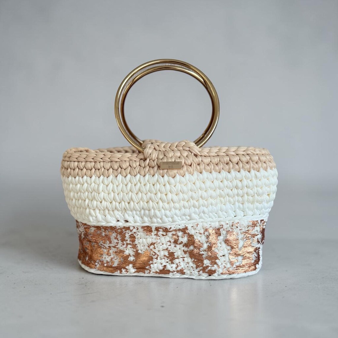 Crochet handbag with hand-applied copper foil texture and gold ring handles