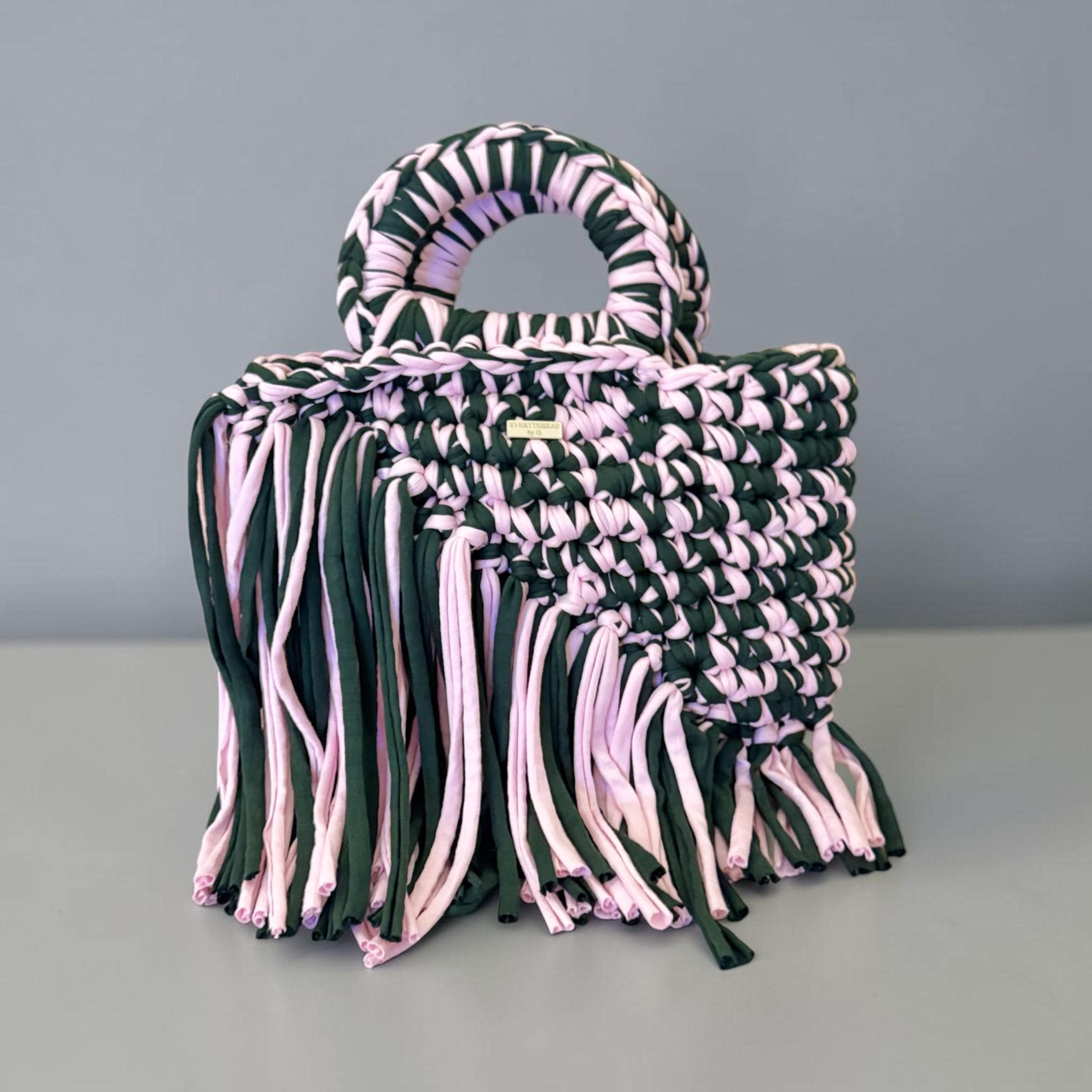 Handmade forest green and blush pink woven crochet handbag with braided handle and fringe