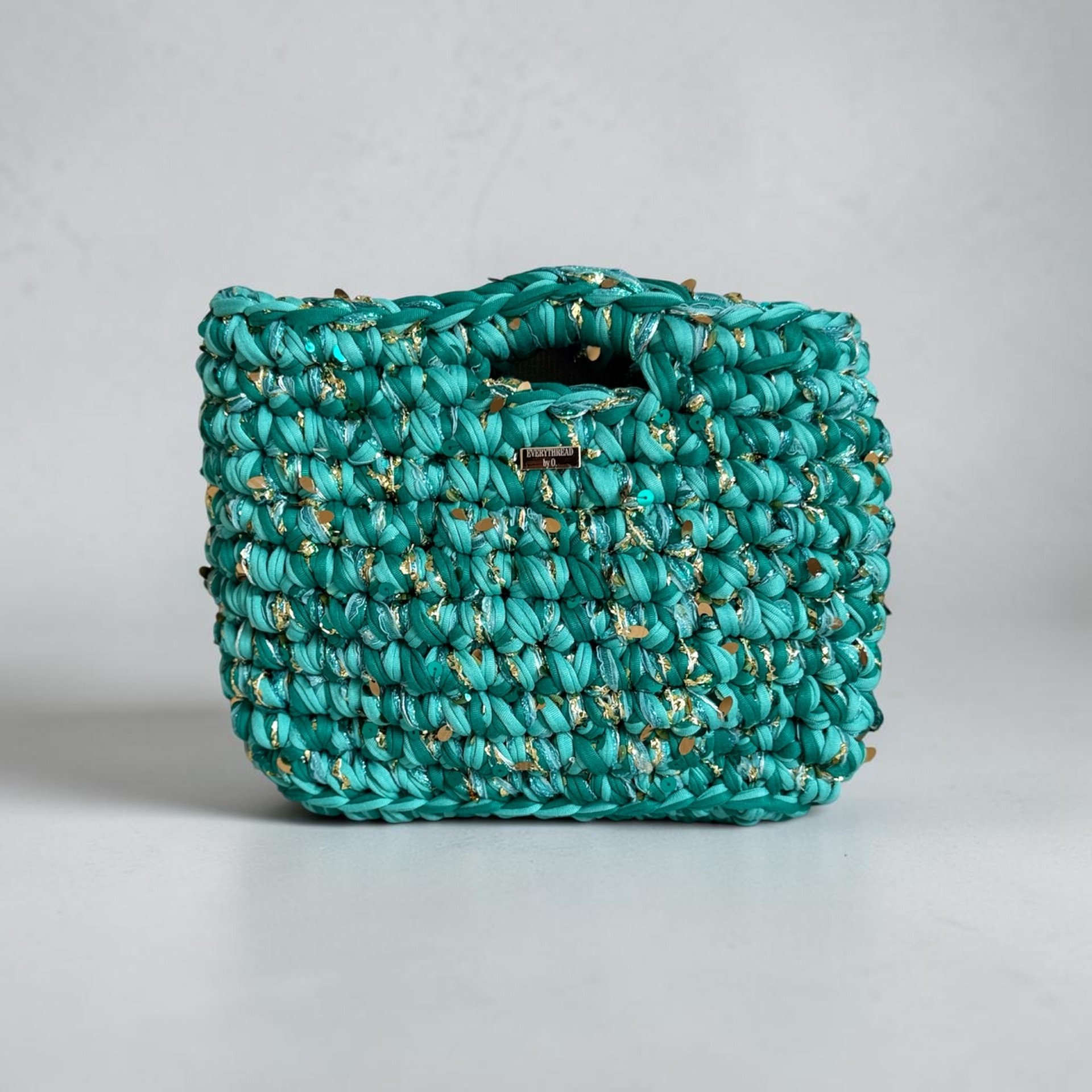 Turquoise crochet statement handbag with gold accents